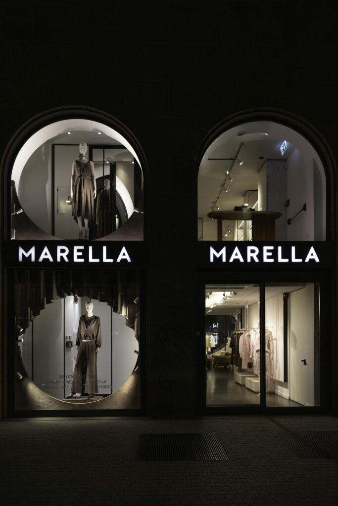 Vetrine notturne del flagship Marella di Corso Vittorio Emanuele con l'installazione Beyond Matter di Cosma Frascina, Milano Design Week 2026