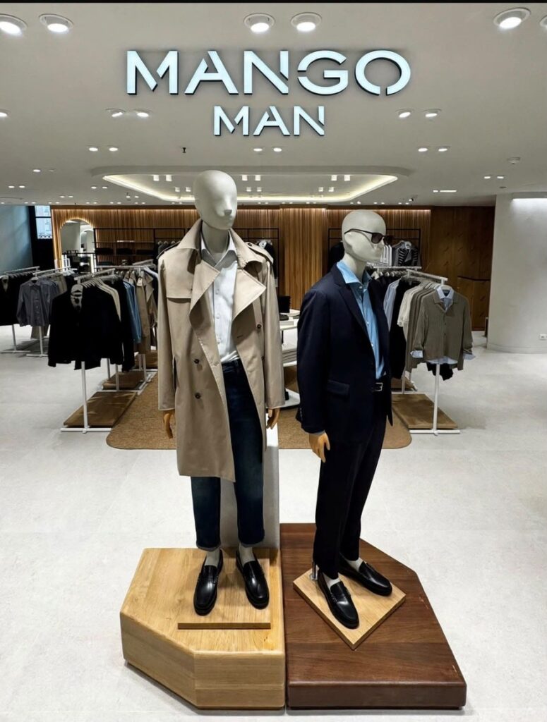 Reparto Mango Man nel nuovo negozio Coin a Catania, con due manichini in trench beige e completo scuro sotto l’insegna.