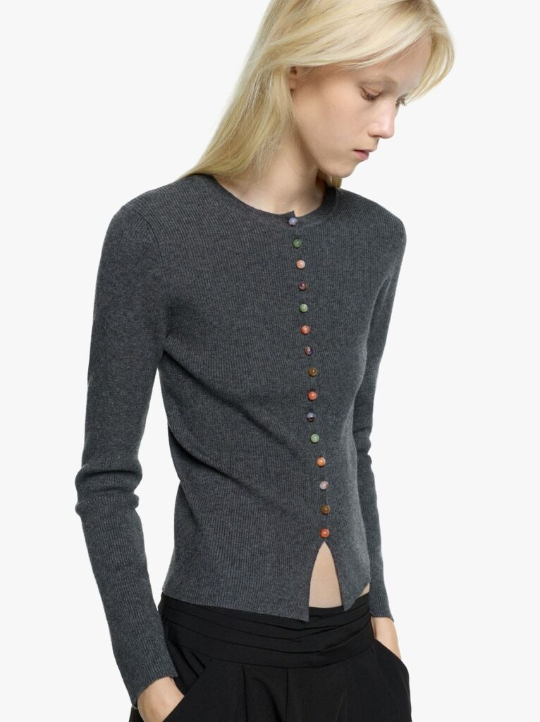 Cardigan grigio Parfois con piccoli bottoni multicolori, indossato con pantaloni neri nella capsule The Edition.