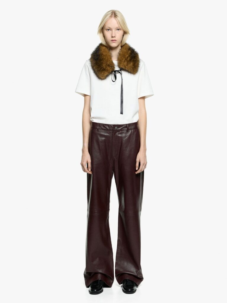 Look Parfois The Edition con pantaloni bordeaux a gamba ampia, T-shirt bianca e collo marrone a pelo lungo chiuso da un nastro.
