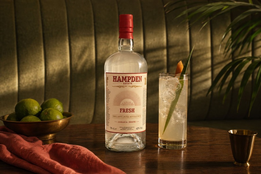 Bottiglia di Hampden Fresh accanto a un cocktail con ghiaccio, una ciotola di lime e un dosatore.