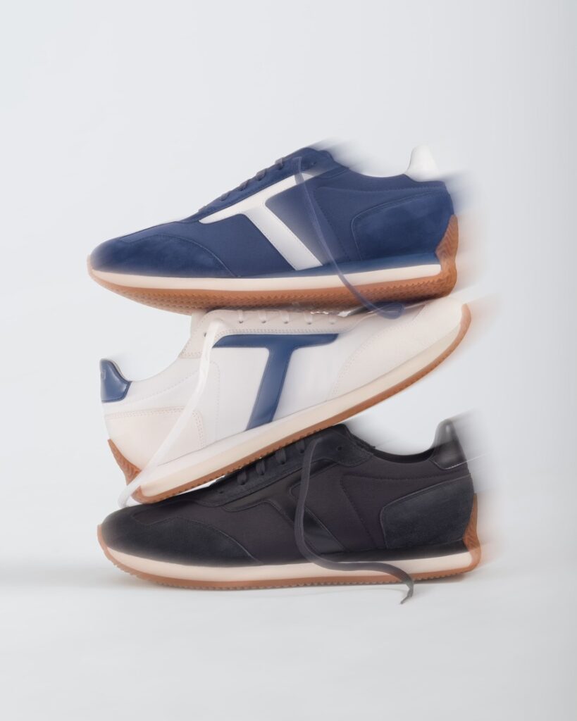 Tre sneakers Testoni con lacci sovrapposte, nelle combinazioni blu e bianco, bianco e blu e nero, con suole color gomma.